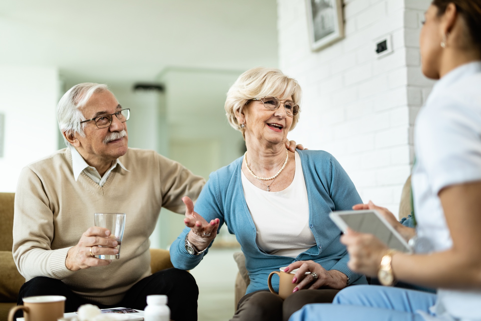 Healthcare professional warmly consulting with a senior couple at home
